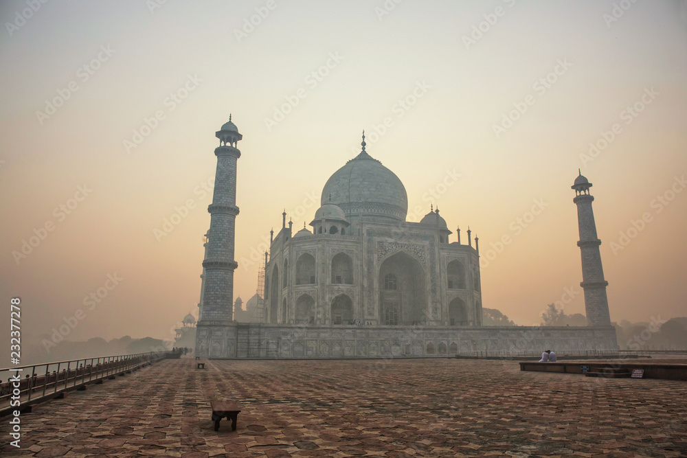 Agra, India. White marble Taj Mahal complex with minarets and walls through the haze and smog