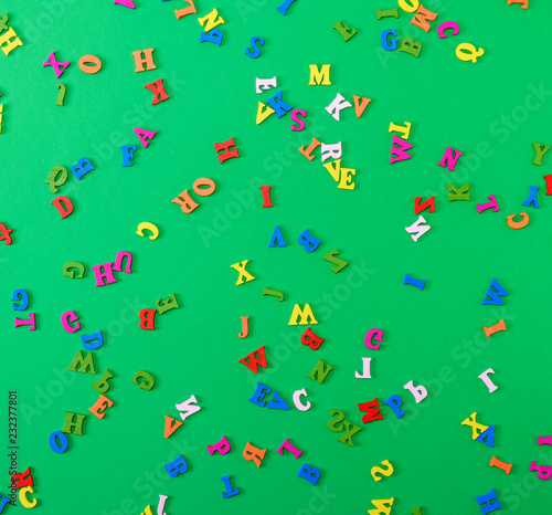 small wooden multi-colored letters of the English alphabet are scattered