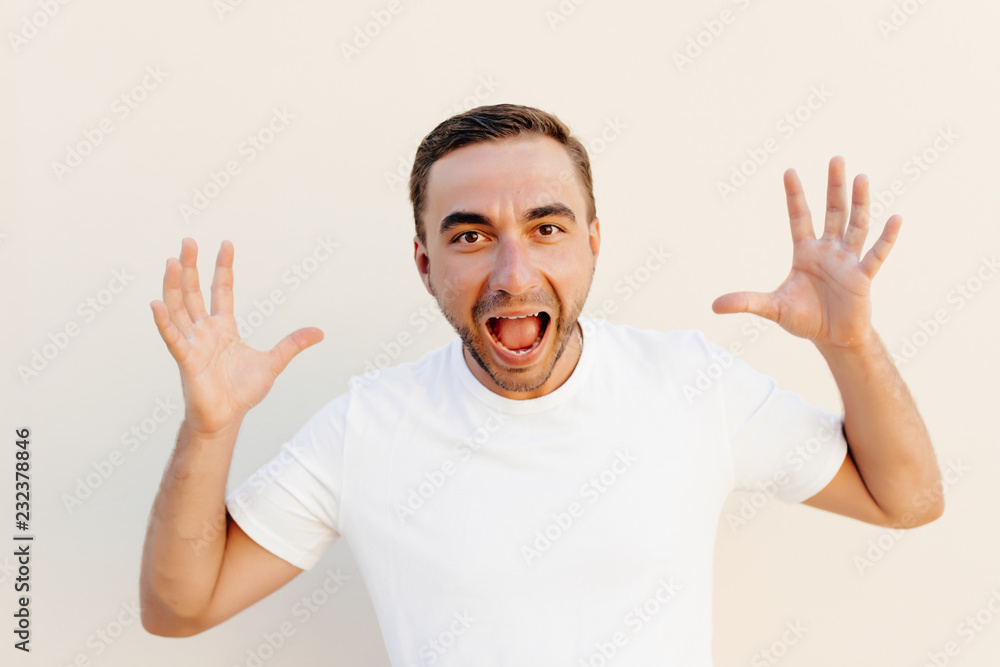 Screaming, hate, rage. Crying emotional angry man screaming on orange studio background. Emotional, young face. male half-length portrait. Human emotions, facial expression concept. Trendy colors Screaming, hate, rage. Crying emotional angry man screaming on orange studio background. Emotional, young face. male half-length portrait. Human emotions, facial expression concept. Trendy colors
