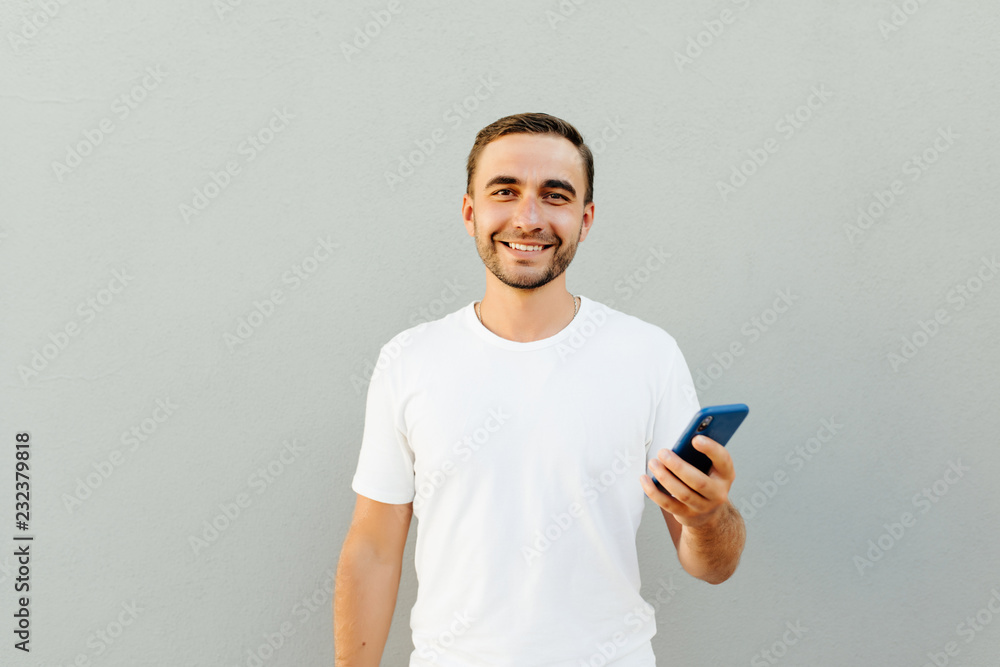 Portrait of excited satisfied having rest relax break pause using smartphone for getting sending sms isolated on gray background Portrait of excited satisfied having rest relax break pause using smartphone for getting sending sms isolated on gray background
