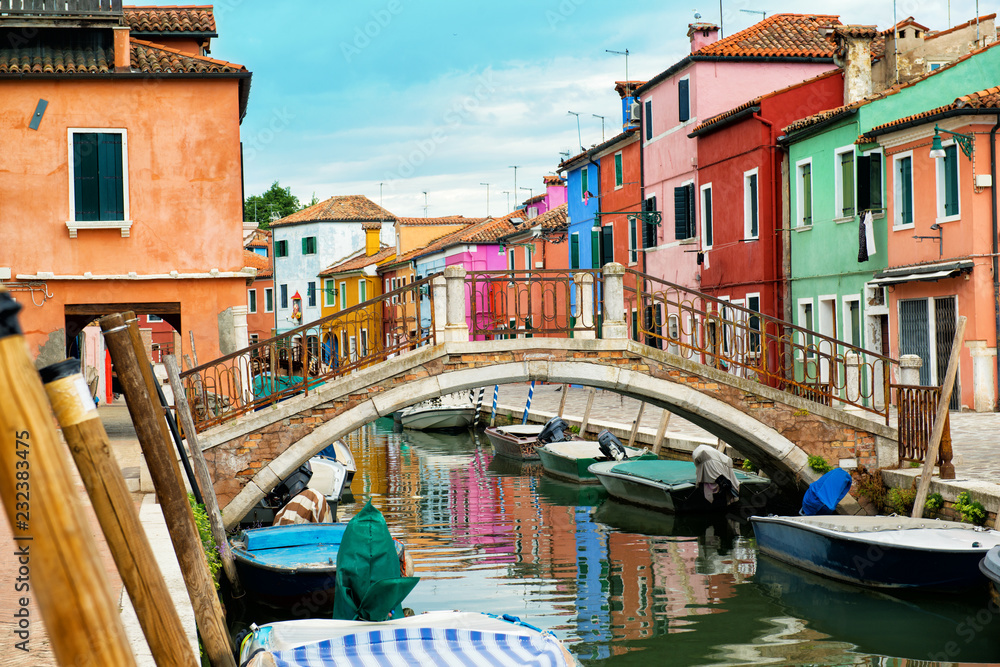 Beautiful street with canal, bridge, boats and multicolored houses, Burano island, Venice, Italy