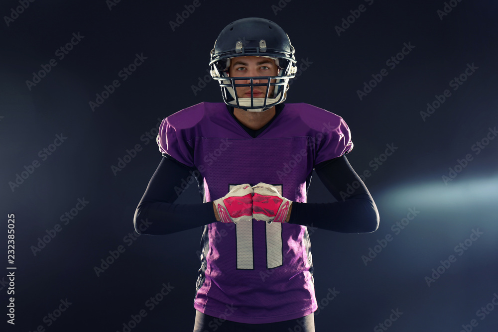 American football player in uniform on dark background