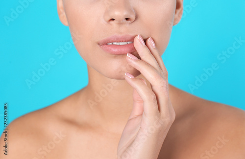Closeup view of beautiful young woman on color background. Lips contouring  skin care and cosmetic surgery concept
