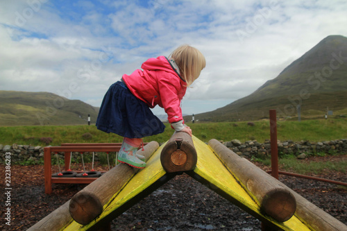 Little Girl playing on a Climbing Frame in the Scottish Highlands 