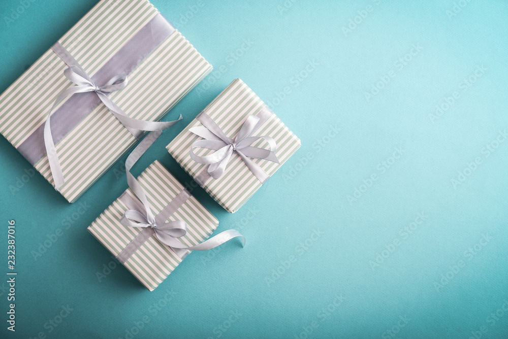 Fototapeta premium Several gift striped boxes with grey ribbon