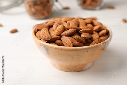 Tasty organic almond nuts in bowl on table