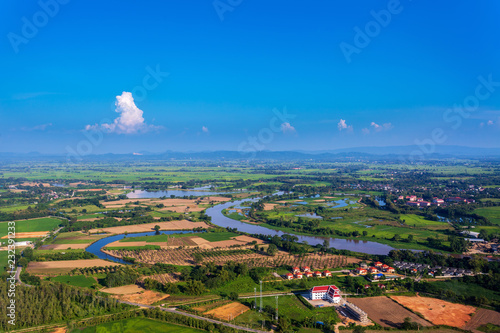 Vászonkép areal shot of rural village in Chiangrai with the river Kok in and bright blue s