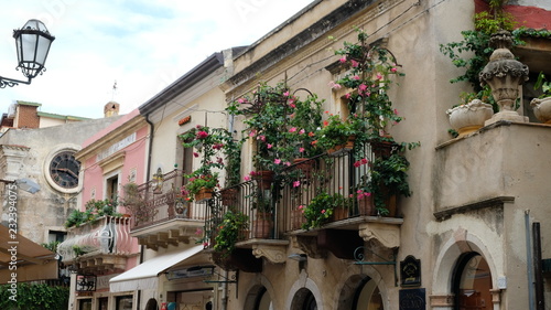 Taormina, Province of Messina, Sicily. All around the city there are beatiful balconies, often decorated with flower pots. This is Corso Umberto, the main street of the city.