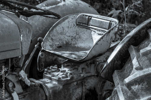 Looking at the drivers seat of a vintage tractor aged and worn from sitting in the sun.