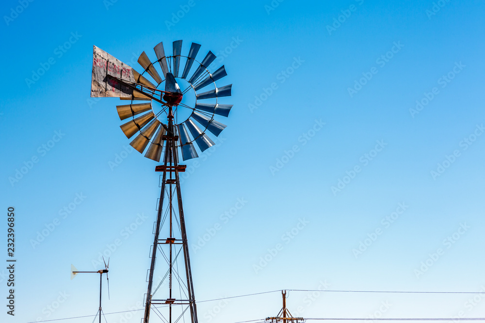 A traditional wind mill next to a wind turbine create a juxtaposition of old and new. A traditional wind mill next to a wind turbine create a juxtaposition of old and new.