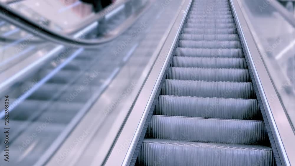 Stair and escalators in a public area. Close-up shot of people moving on escalator - cinematic tone. Staircase running up and down at big store. Stair and escalators in a public area. Close-up shot of people moving on escalator - cinematic tone. Staircase running up and down at big store.