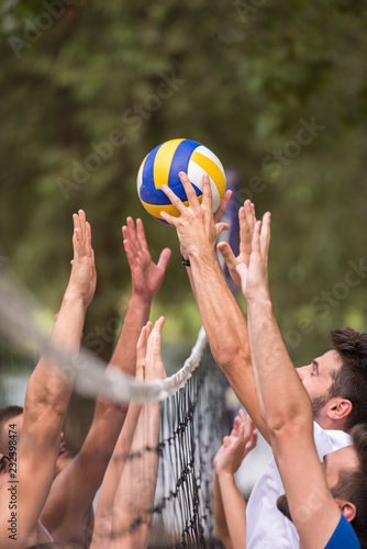 group of young friends playing Beach volleyball