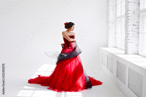 A young woman in a red dress is dancing. Latin style. Isolate on white photo