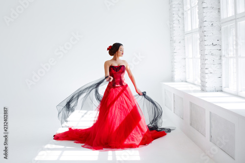 A young woman in a red dress is dancing. Latin style. Isolate on white photo