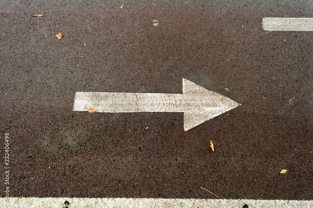 Fototapeta premium asphalt road with drawn arrows pointing to two directions. Making decisions and making choices