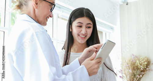 Doctor meeting and explaining medication to woman patient in his office at Hospitals