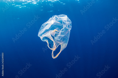 Underwater pollution:- A discarded plastic carrier bag drifting in a tropical, blue water ocean © whitcomberd