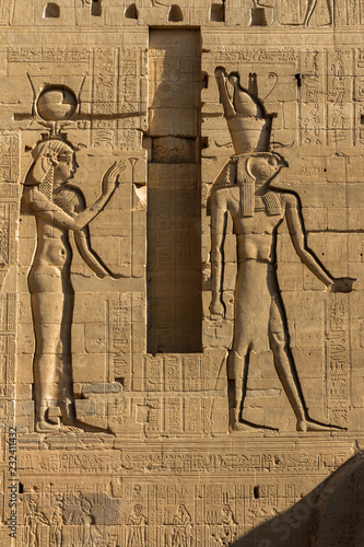 Relief Carvings of Hathor and Osiris flanking the center doorway on the First Pylon of the Temple of Isis at Philea, Aswan Egypt