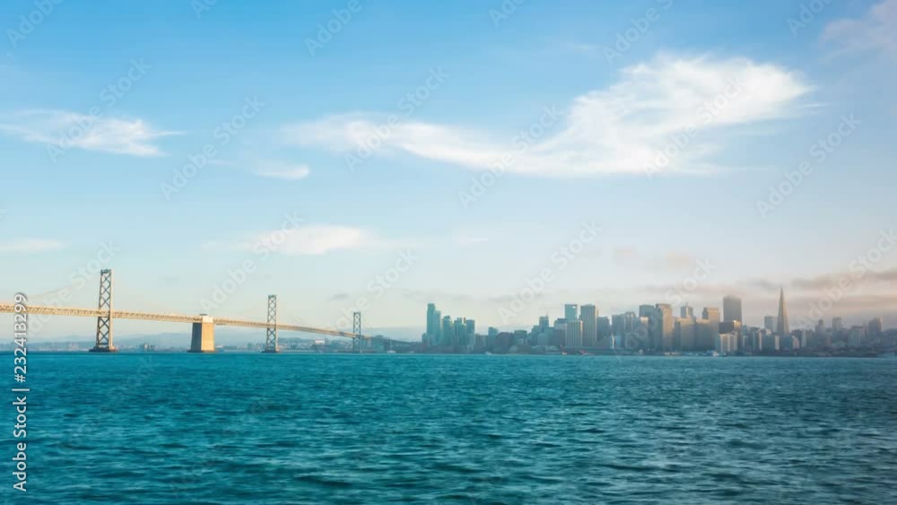 San Francisco skyline, waterfront, Bay Bridge transitioning from blue sky day to sunset clouds to blue hour evening then night city lights seen from Treasure Island. Zoom out 4k time-lapse at 30fps San Francisco skyline, waterfront, Bay Bridge transitioning from blue sky day to sunset clouds to blue hour evening then night city lights seen from Treasure Island. Zoom out 4k time-lapse at 30fps
