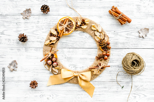 Christmas decoration concept. Creative christmas wreath made of thread near matherials and instruments, sciccors on white wooden background top view photo