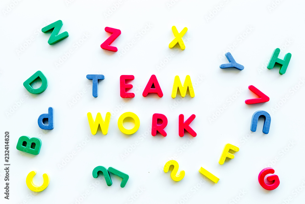 Teamwork training concept. Text teamwork lined with colored letters in frame of toy letters on white background top view