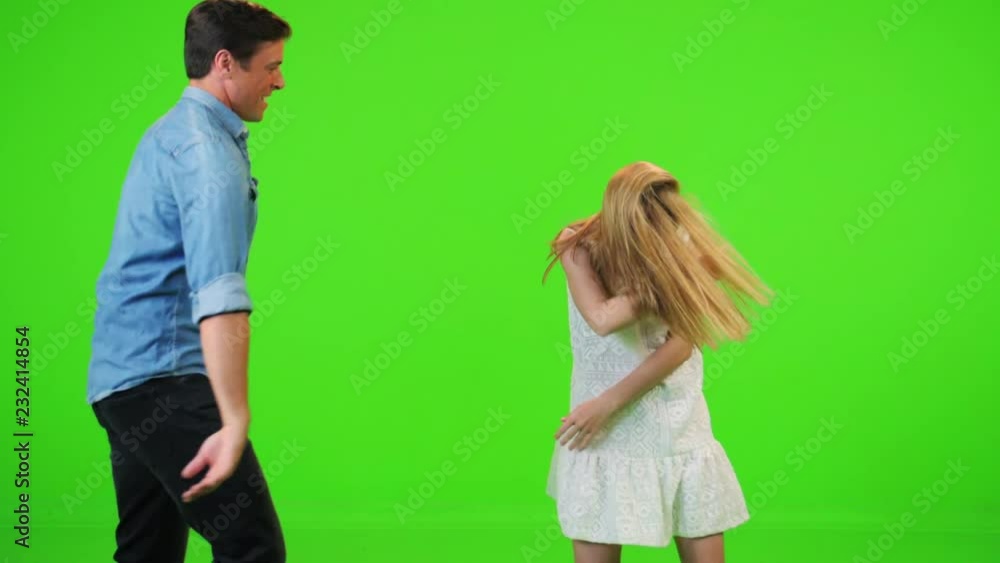 Slow motion couple dances happily over a green screen, stops and looks into the camera. Slow motion couple dances happily over a green screen, stops and looks into the camera.