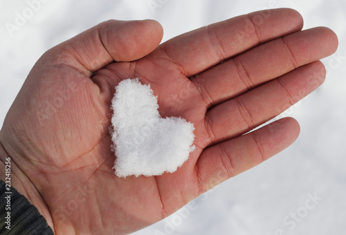 Snow heart shaped melting in your palm as love symbol