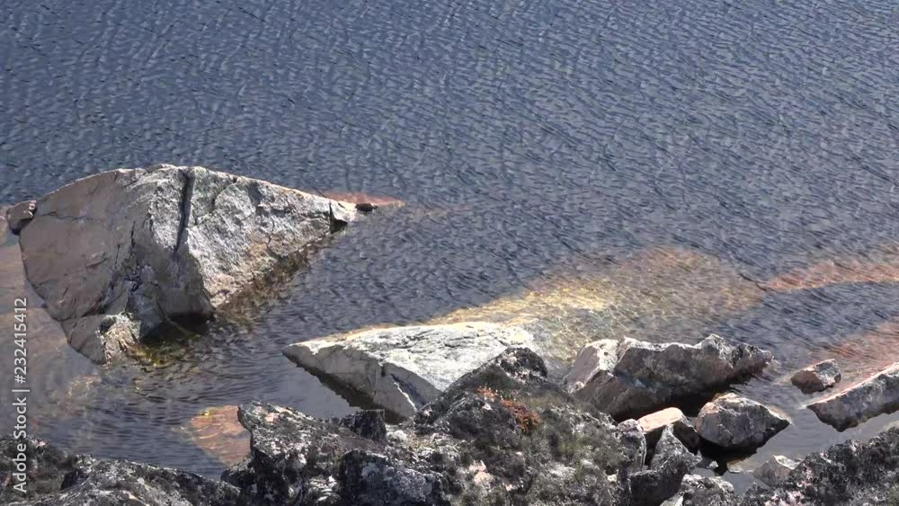 Water ripples on the rocky shore of a mountain lake. Water ripples on the rocky shore of a mountain lake.
