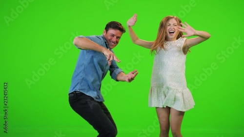 Slow motion jumping and dancing by a man and a woman over a green screen.