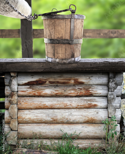 Wooden rustic fountain with bucket in a natural decor