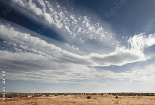 Blue sky filled with white clouds above prarie landscape