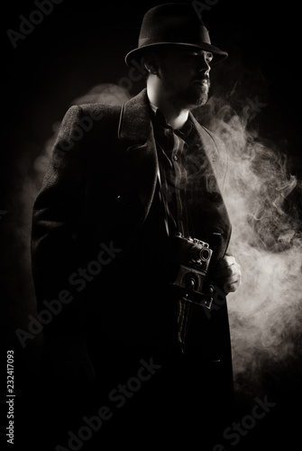 man in a black hat and coat on a dark background, Studio photo