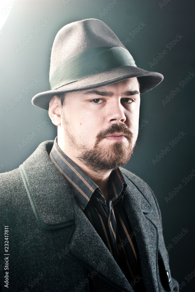 portrait of a man in a black hat and coat on a dark background, Studio photo portrait of a man in a black hat and coat on a dark background, Studio photo