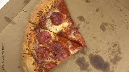 Leftover pieces pepperoni pizza in greasy box