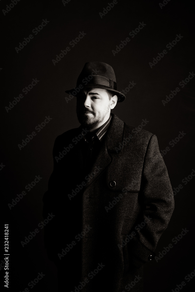 man in a black hat and coat on a dark background, Studio photo man in a black hat and coat on a dark background, Studio photo