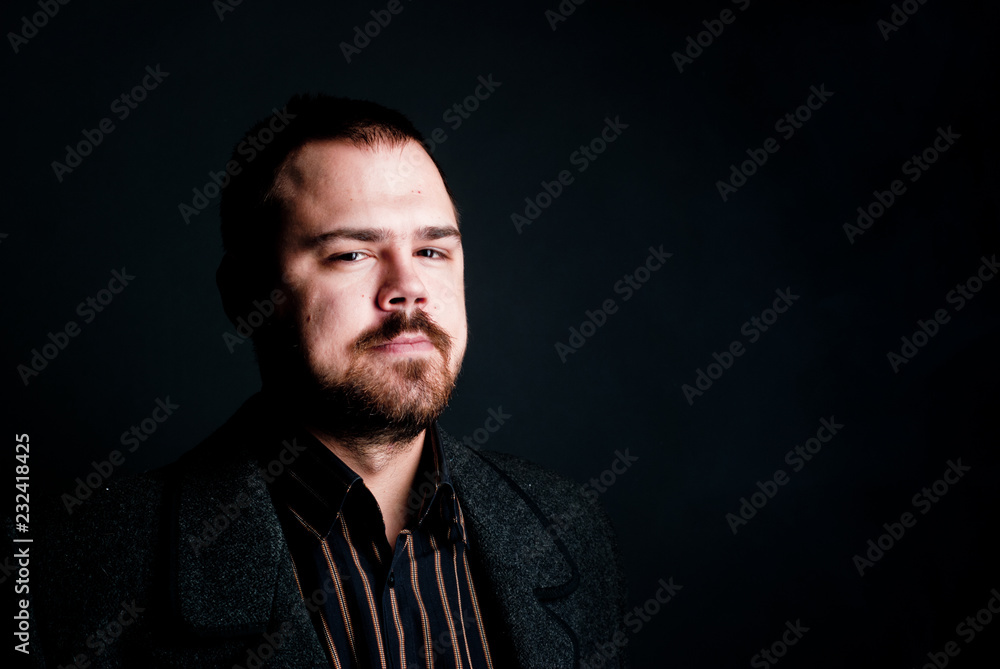 portrait of a man in a black coat on a dark background, Studio photo