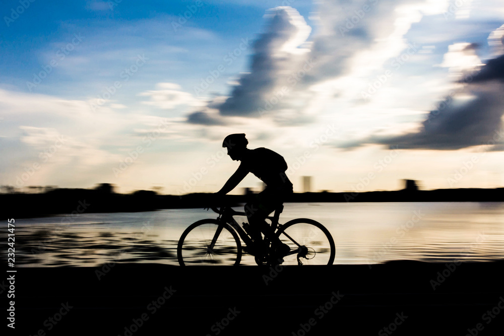 Fototapeta premium Men exercise with bike in the park in the evening with the blue sky