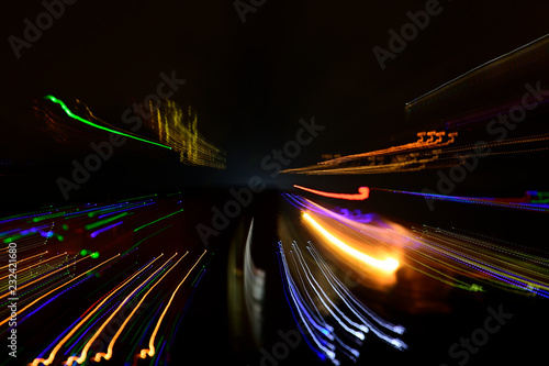 Motion blur car light trails on highway against black background.