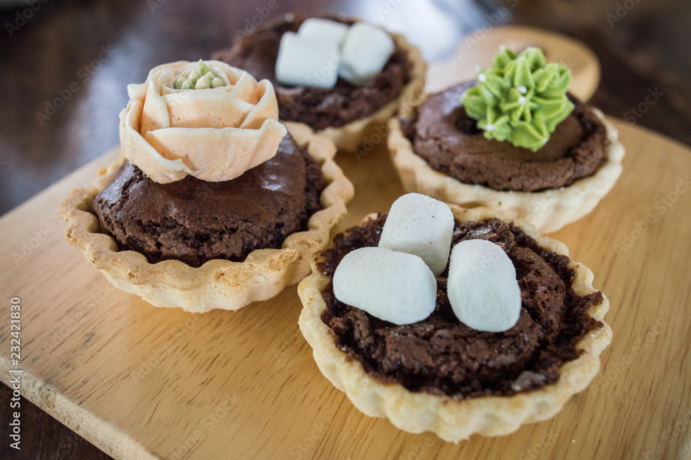 Close-up of Assorted mini brownie tart serving on the wooden table. Close-up of Assorted mini brownie tart serving on the wooden table.