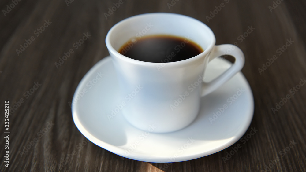 Black hot coffee on table with sunlight, relaxation concept and soft focus idea Black hot coffee on table with sunlight, relaxation concept and soft focus idea