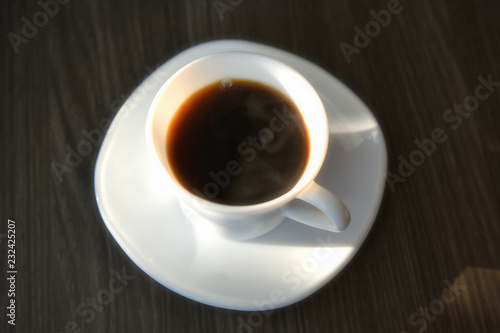 Flat lay of black hot coffee with sunlight on table