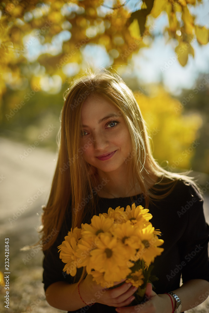 portrait of young woman in autumn park with flowers portrait of young woman in autumn park with flowers