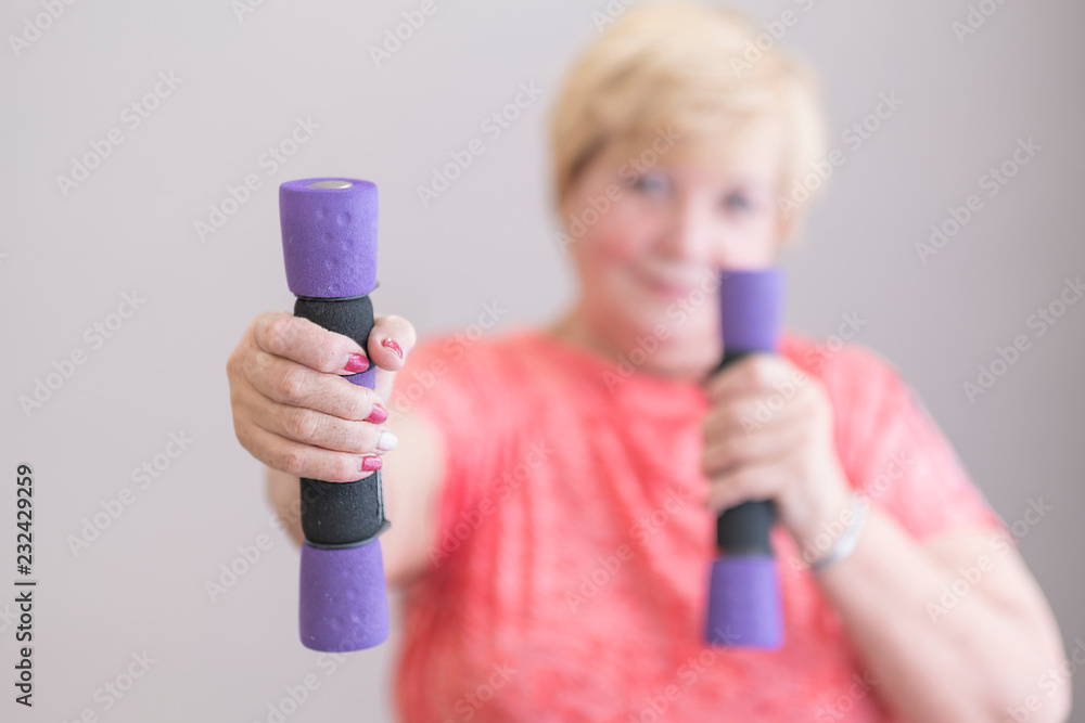 Senior woman training, doing fitness with pink weights at home. Senior woman training, doing fitness with pink weights at home.