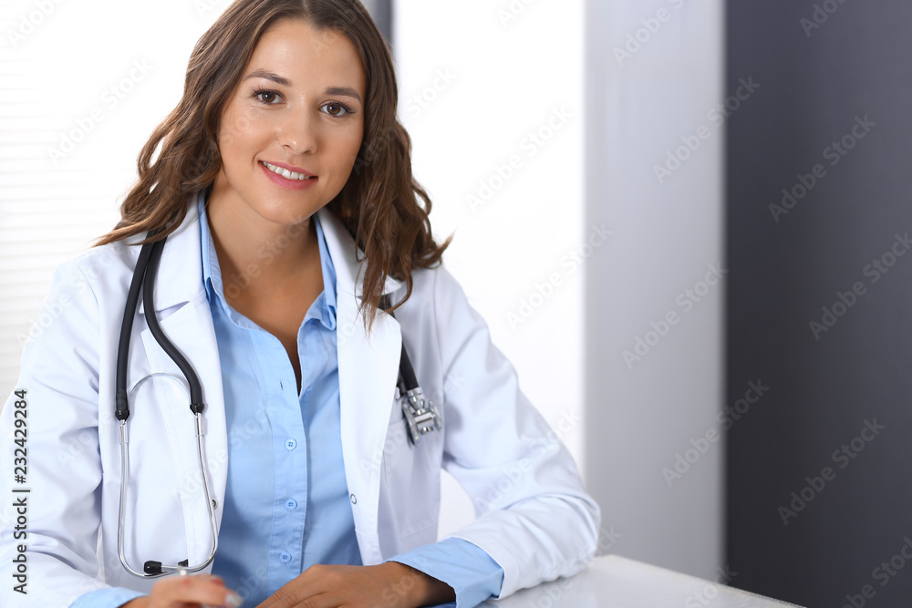 Doctor woman filling up medical form while sitting at the desk in hospital office. Physician at work. Medicine and health care concept Doctor woman filling up medical form while sitting at the desk in hospital office. Physician at work. Medicine and health care concept