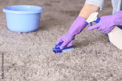 Woman cleaning carpet at home