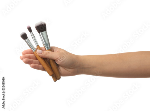 Woman holding makeup brushes on white background