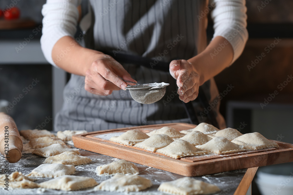 Woman making tasty ravioli on table