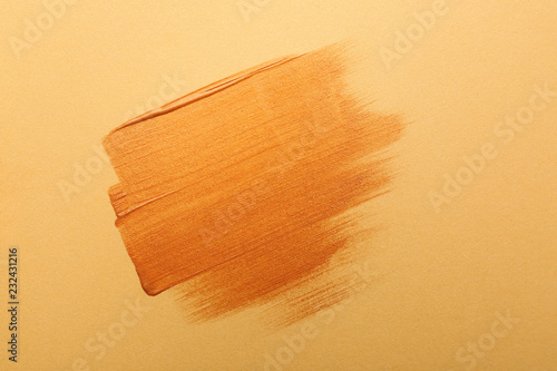 Strokes of gold paint on color background