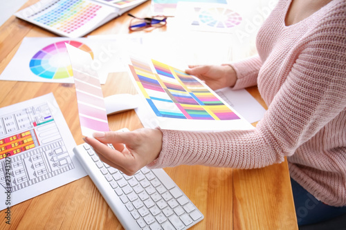 Beautiful young designer working with color palette in office