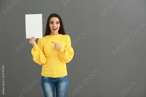 Young woman with blank shee...